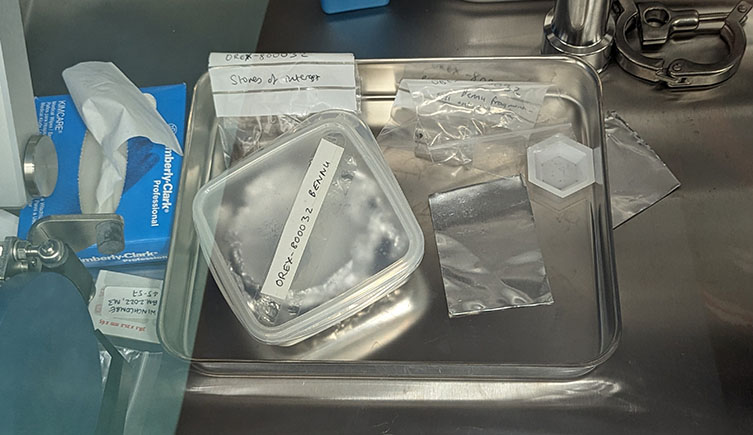 The samples at the Museum, showing a tuppaware box that has a lable on it reading "Bennu". 