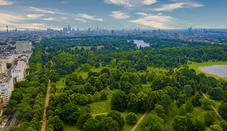 An aerial photo of Hyde Park in London, with the green space ringed by buildings.