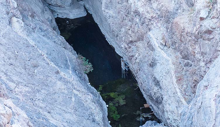 Devils Hole, a narrow water-filled opening among sheer sided rock walls.