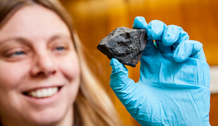 Sara Russell holds up a meteorite
