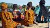 a group of people in traditional African dress sit to watch a performance