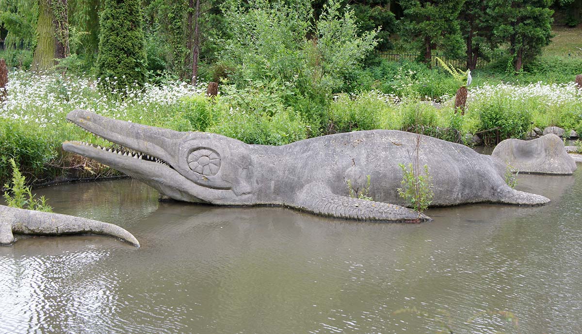 A sculpture of the ichthyosaur Temnodontosaurus in a shallow pool of water in Crystal Palace Park. 