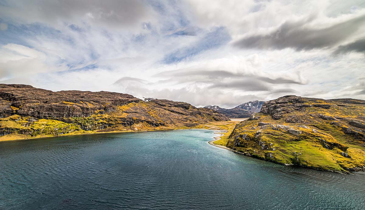 An aerial view of the Kerguelen Islands under a cloudy sky.