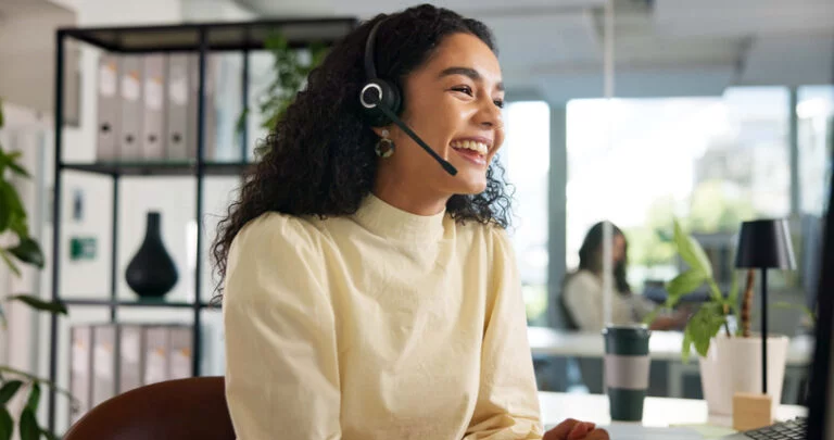 Happy customer service woman in call centre on a call to customer.