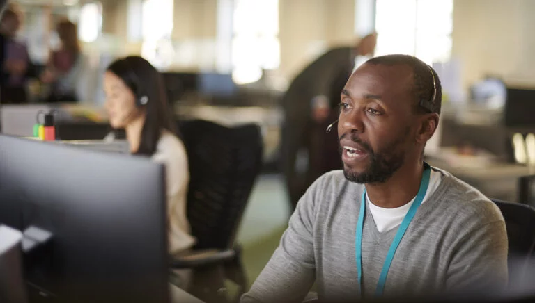 call center worker with headset in front of computer.