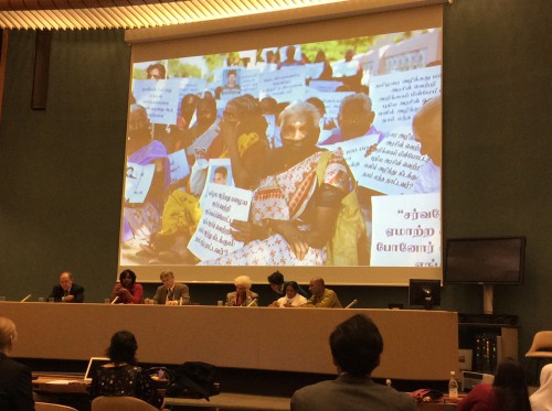 Panellists Juan Mendez, Bhavani Fonseka, Peter Splinter, Estela Barnes de Carlotto, Sandhay Ekneligoda,and Ruki Fernando with a photo of families of the disappeared protesting before Sri Lanka's Commission on Missing Persons