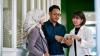 Three people looking at a tablet