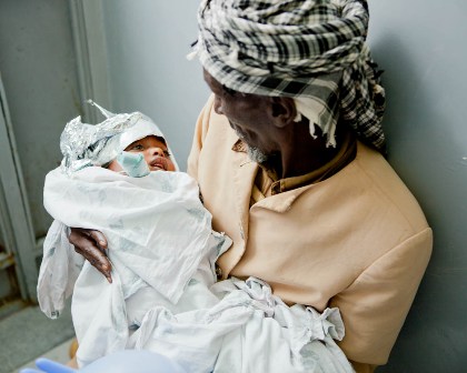 Father holding his child after a surgical procedure in Ethiopia