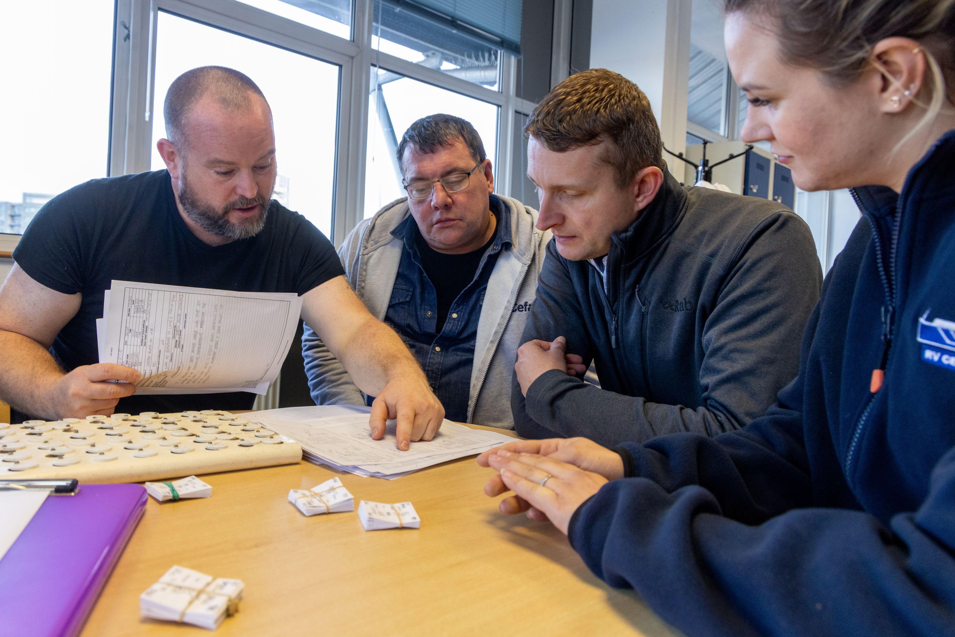 People looking at a document, sat around a table