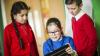a group of pupils working together on a tablet