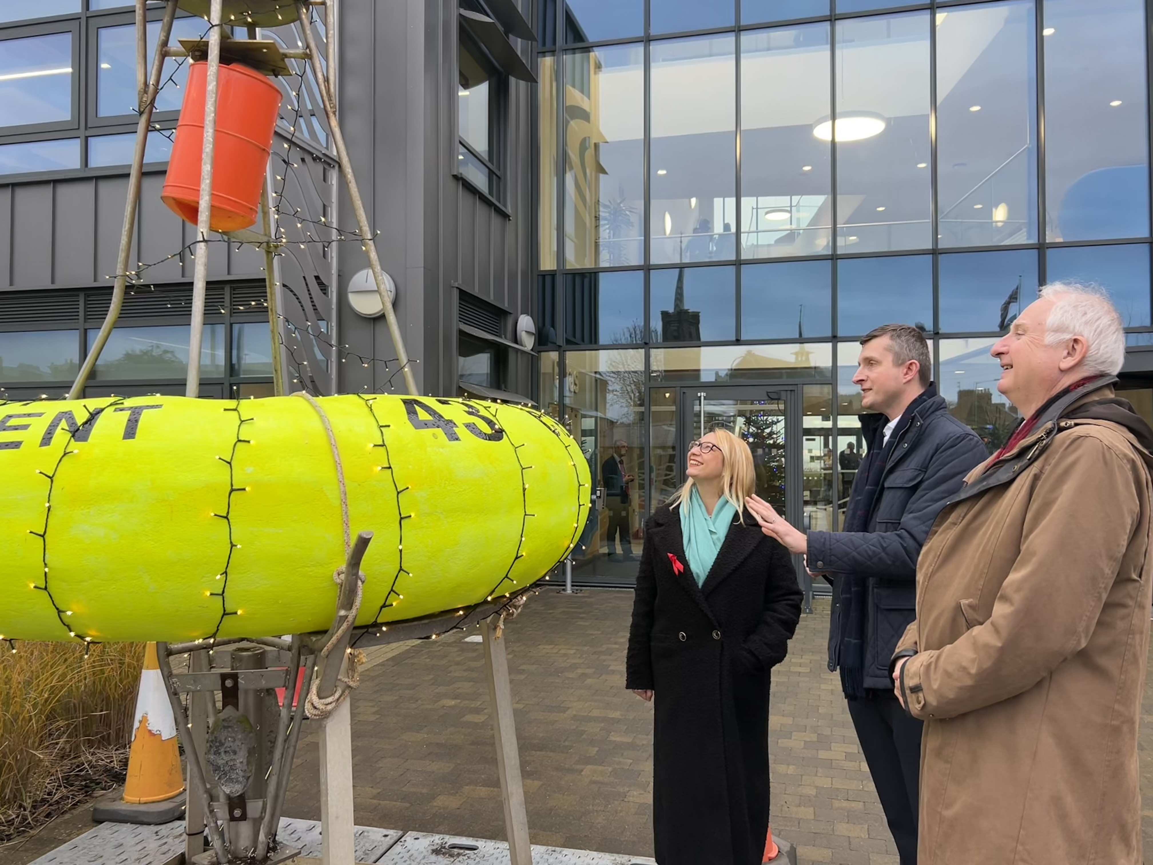 A group of people outside a building looking at a smartbuoy