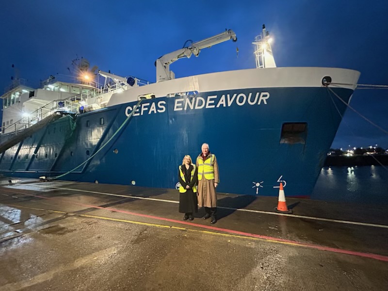 Two people stood in front of a boat