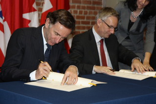 Ministers Lord Green and Ed Fast signing the JIS Signing Ceremony