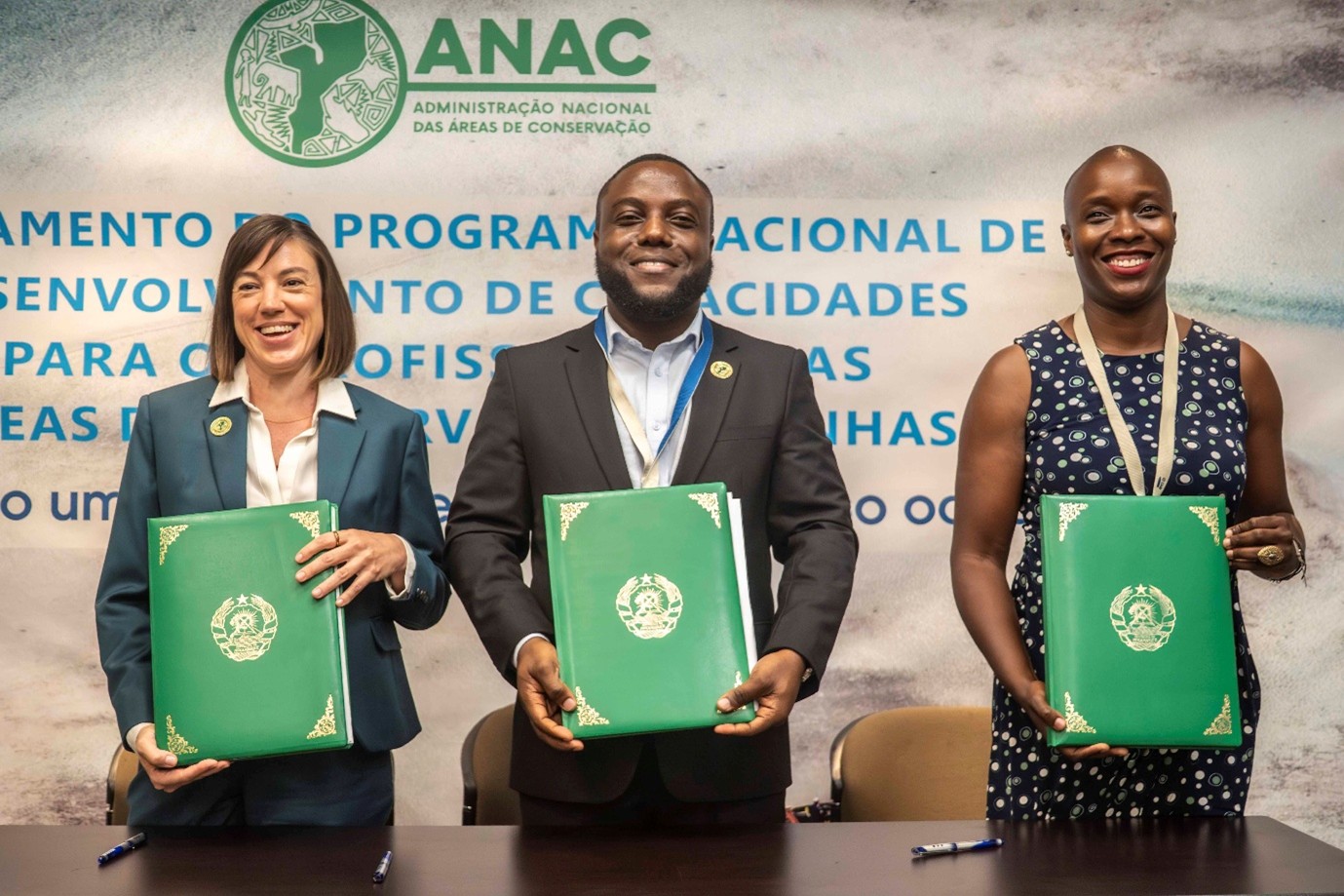 Image of Academy launch event with three people smiling and holding syllabus documents