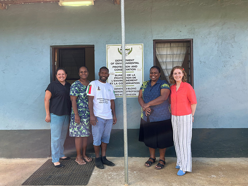 5 people standing by a DEPC sign, smiling for the camera