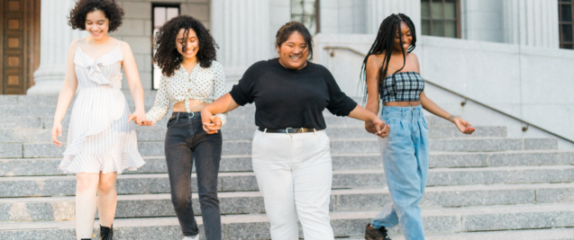 Four young women holding hands