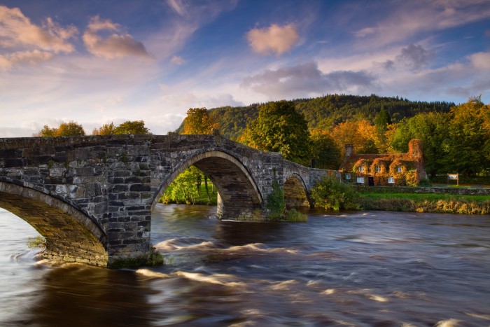 Tu Hwnt Ir Bont, a former courthouse, and the 17th century Pont Fawr stone bridge on the river Conwy. Sunset, dusk.