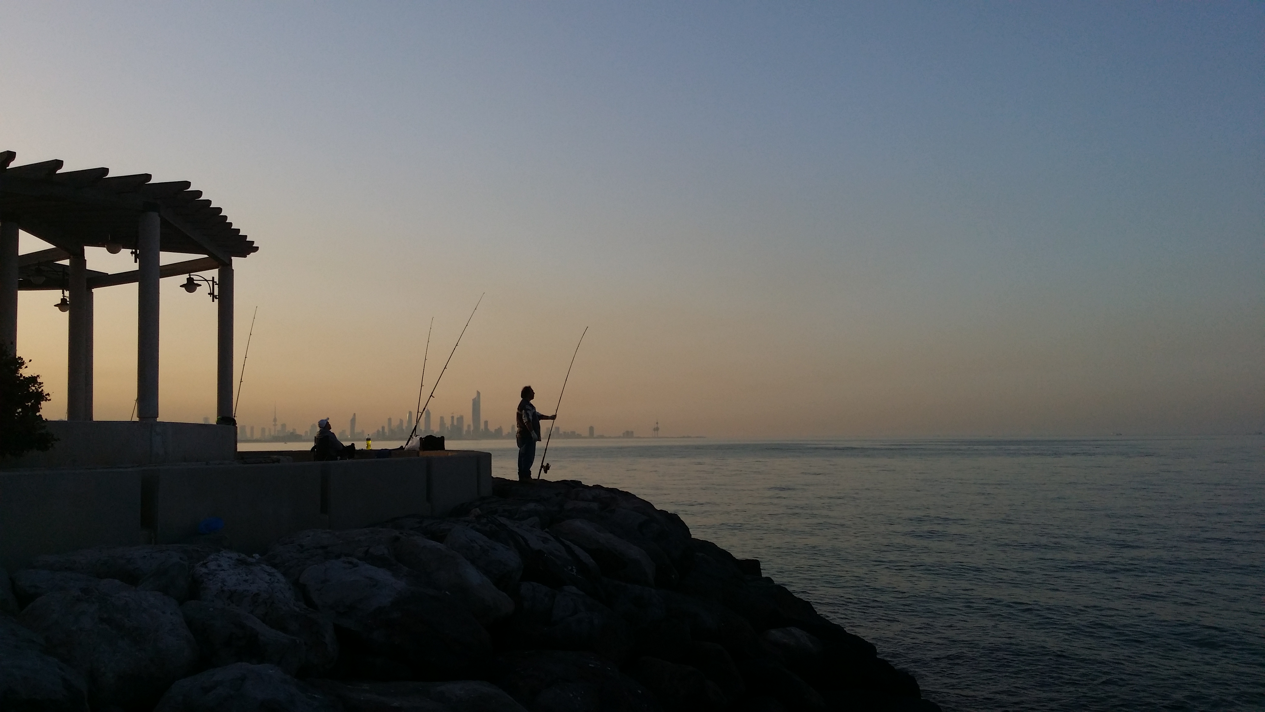 two people at sunset fishing 