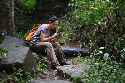 young woman on mobile phone in a forest