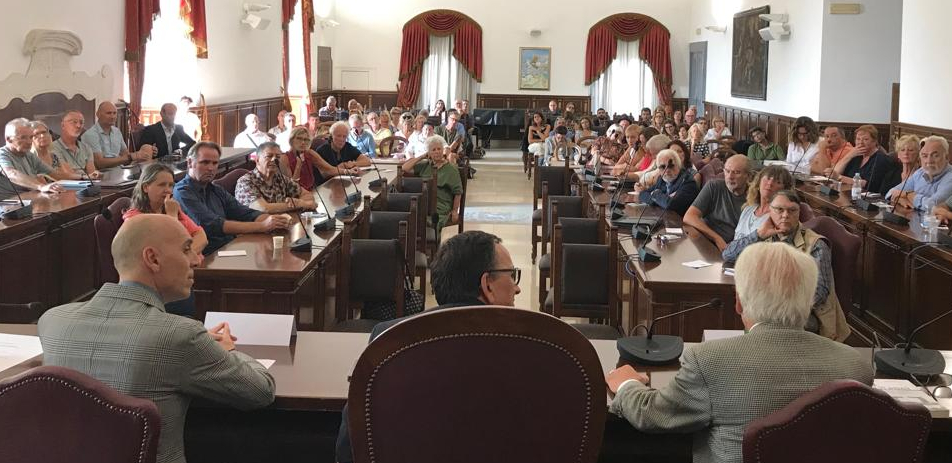 Three people talking to a room full of people.