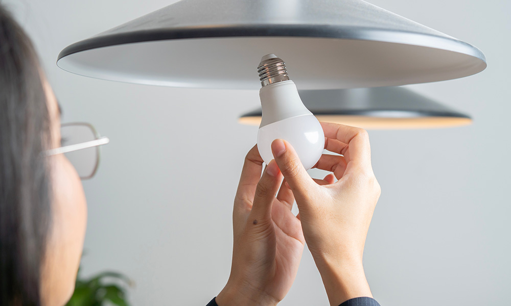 A person screwing in an LED bulb