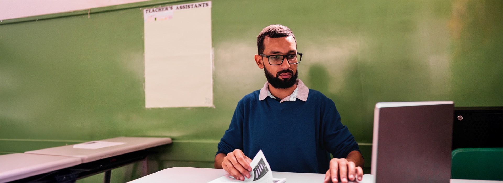 A teacher grading tests in a classroom
