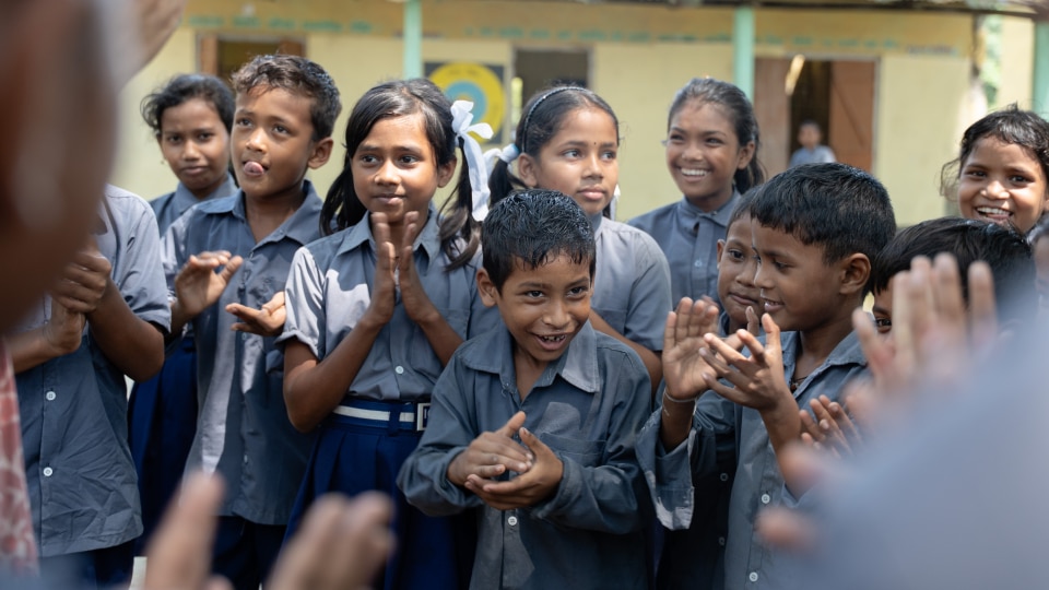 Group of happy South Asian school children clapping