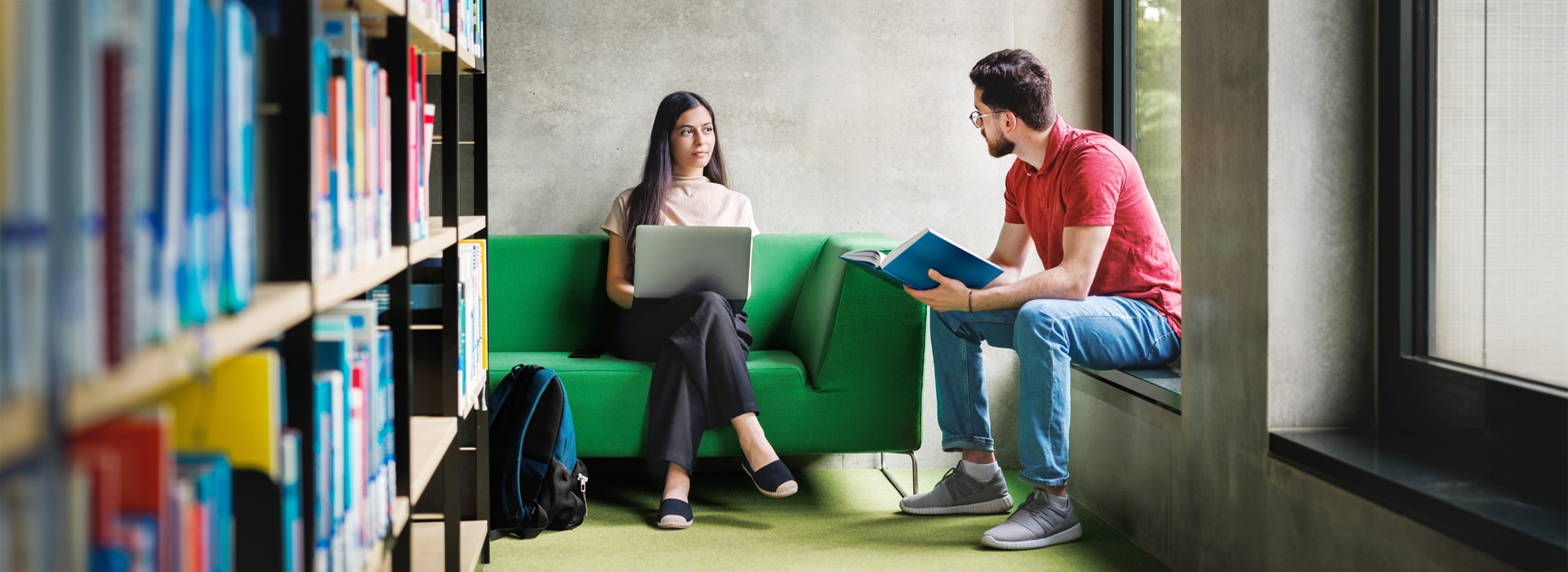Two post graduate students discuss in the library