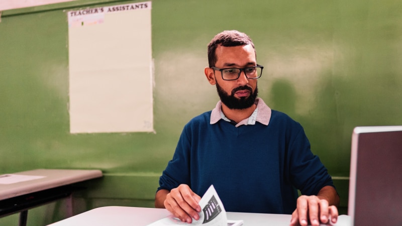 A teacher grading tests in a classroom