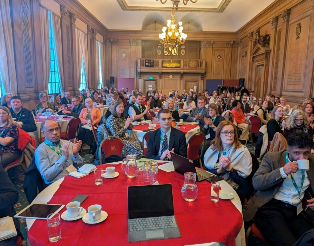 Civil Servants attending Leeds Good Work, Health and Skills Summit sat at tables clapping