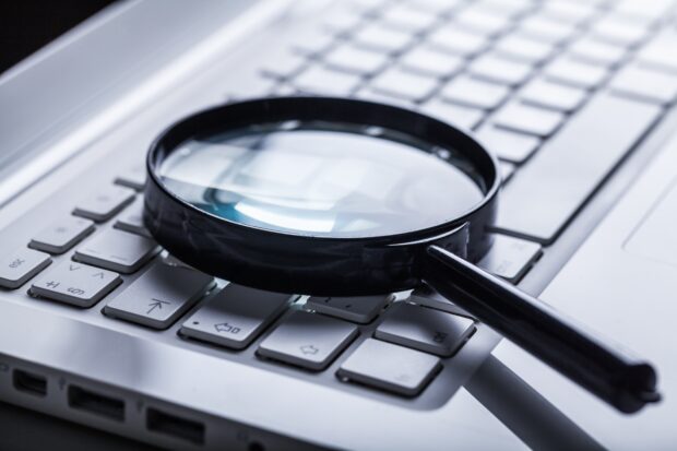 Magnifying glass lying on computer keyboard