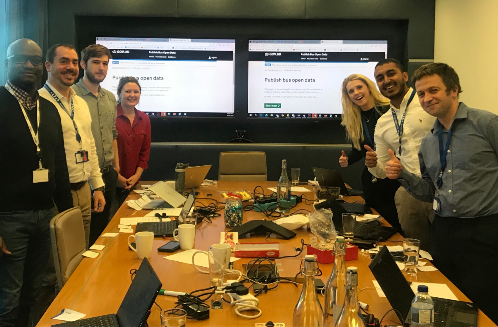 the Buses Open Data team around a meeting table, smiling for the camera