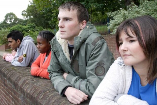 teenagers leaning on a wall