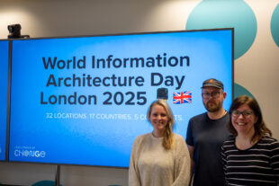 Three information architects standing in front of a large screen displaying a presentation slide which reads: “World Information Architecture Day London 2025. 32 locations, 17 countries, 5 continents.”