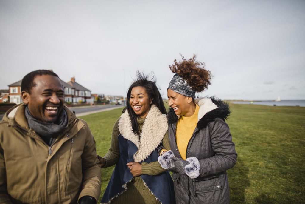 A mother, father and daughter walking together and laughing.