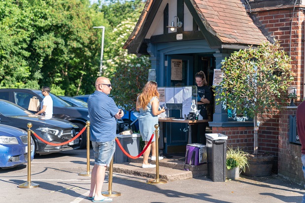 People socially distancing outside a pub