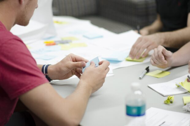 Group sitting at a table and brainstorming with post it notes