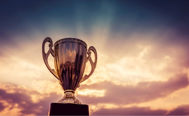 A shiny trophy surrounded by sunlight breaking through clouds.