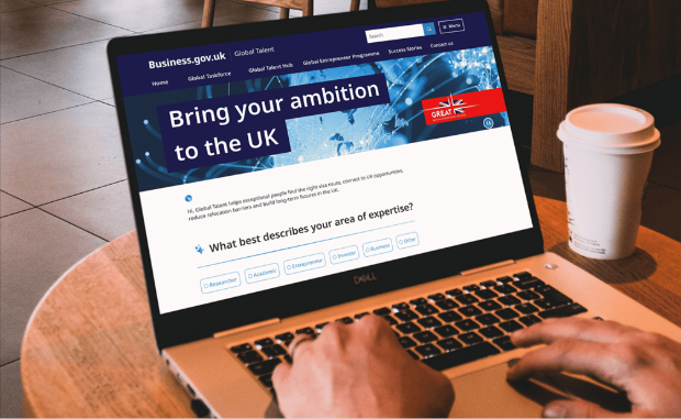 A laptop displaying a Business.gov.uk webpage titled "Bring your ambition to the UK”. The webpage features a navigation bar with options like Home, Global Taskforce, Global Talent Hub, and a section prompting users to select their area of expertise from Researcher, Academic, Entrepreneur, Investor, Business and Other.