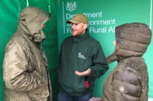 Michael Sturla, member of the Engagement Team, in discussion with farmers at an auction mart in the rain.