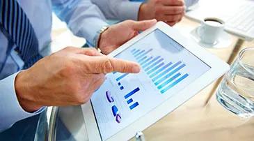 Someone pointing at finance graphs on a tablet device