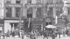 The British Council House many years ago. A very grand building with flags draped outside and a busy street scene out front 