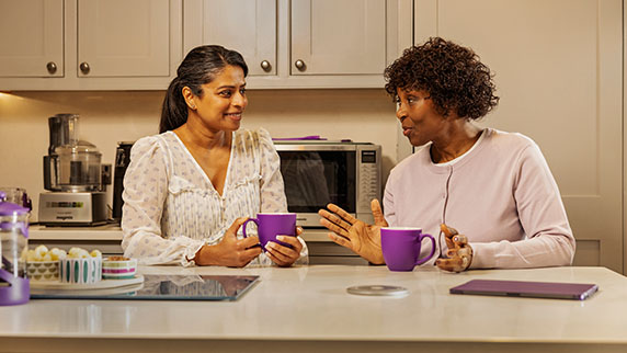 Two women in a kitchen chatting