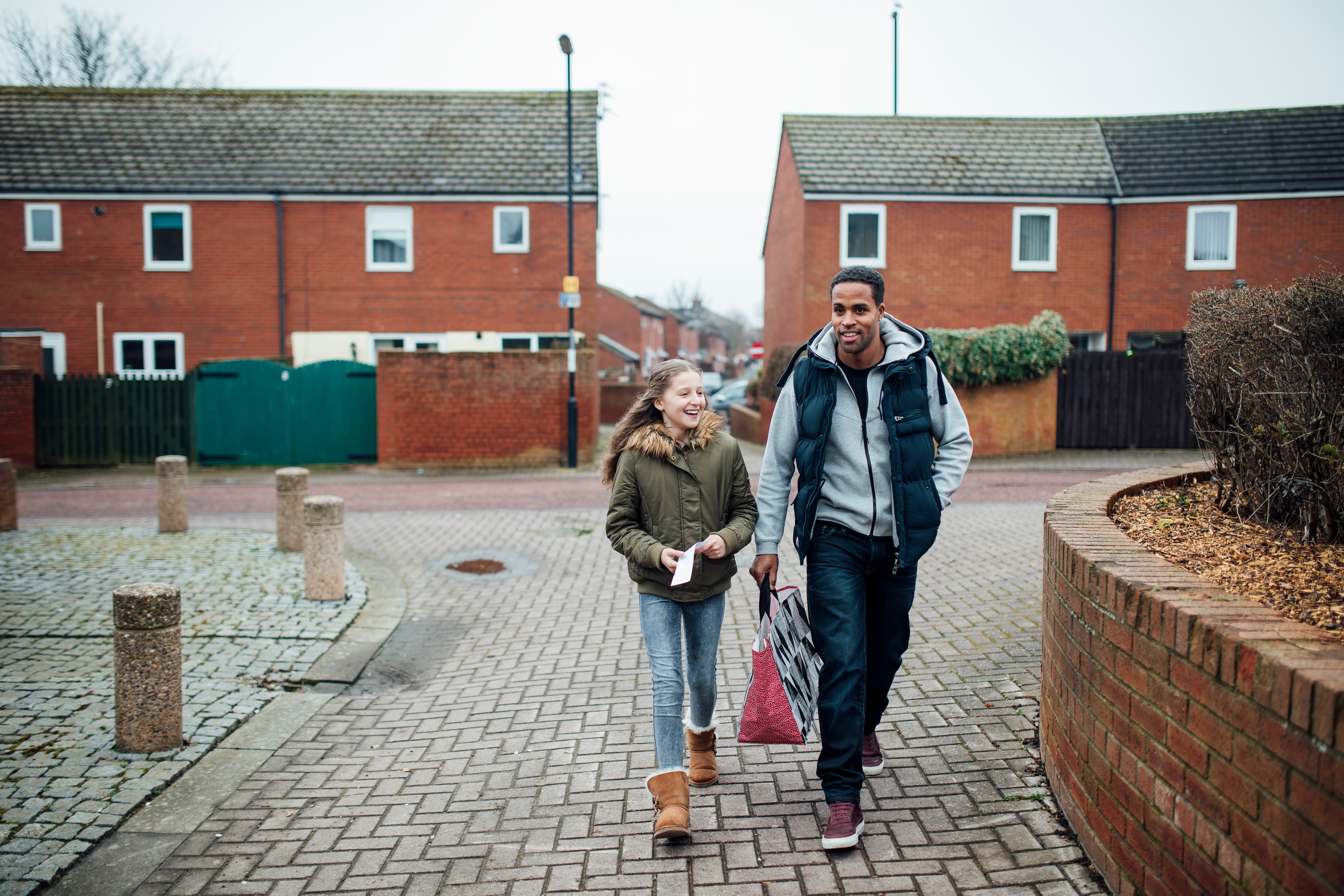 Photo of male carrying bag with young girl