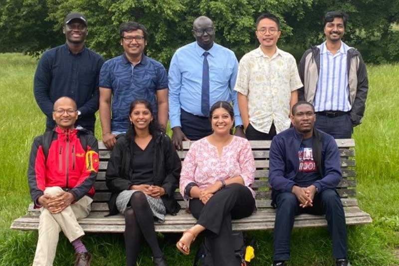 Scholars at the Cambridge London meet-up sat on a park bench