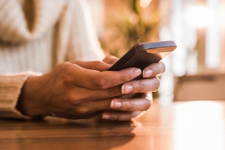Hands typing into a mobile phone