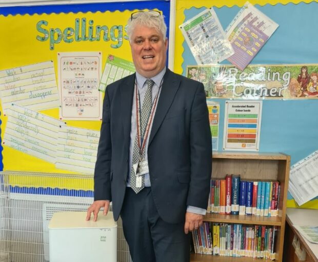 A photo of Richard Lane, standing next to air cleaning unit