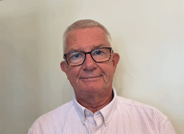 Image of Nick smiling, against a white wall.