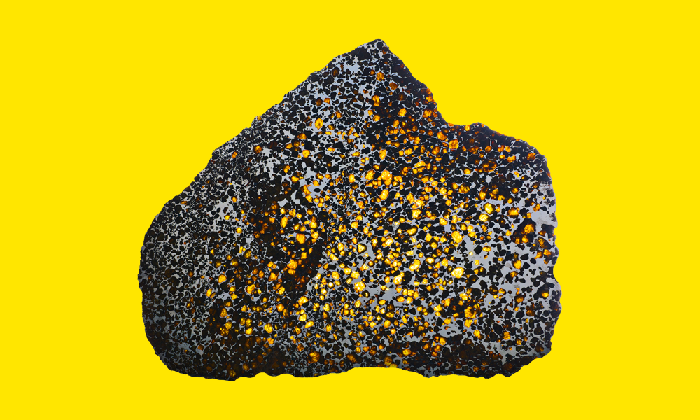 A photo of a meteorite against a yellow background