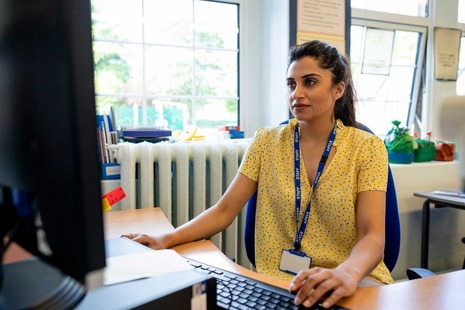 A teacher in a school using a computer